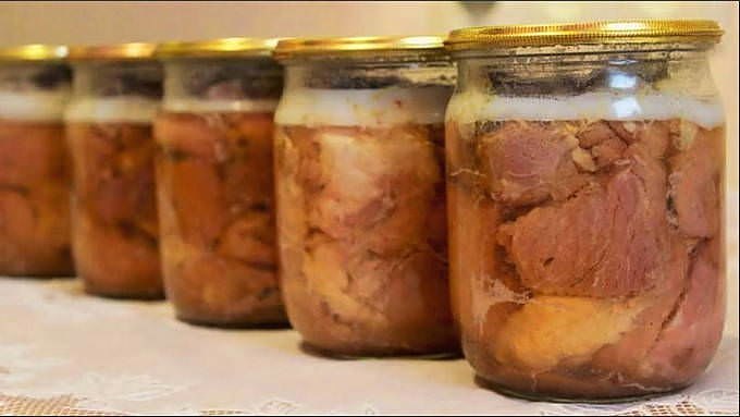 Домашня тушонка у скляних банках — шматки м'яса у власному соку з шаром жиру зверху